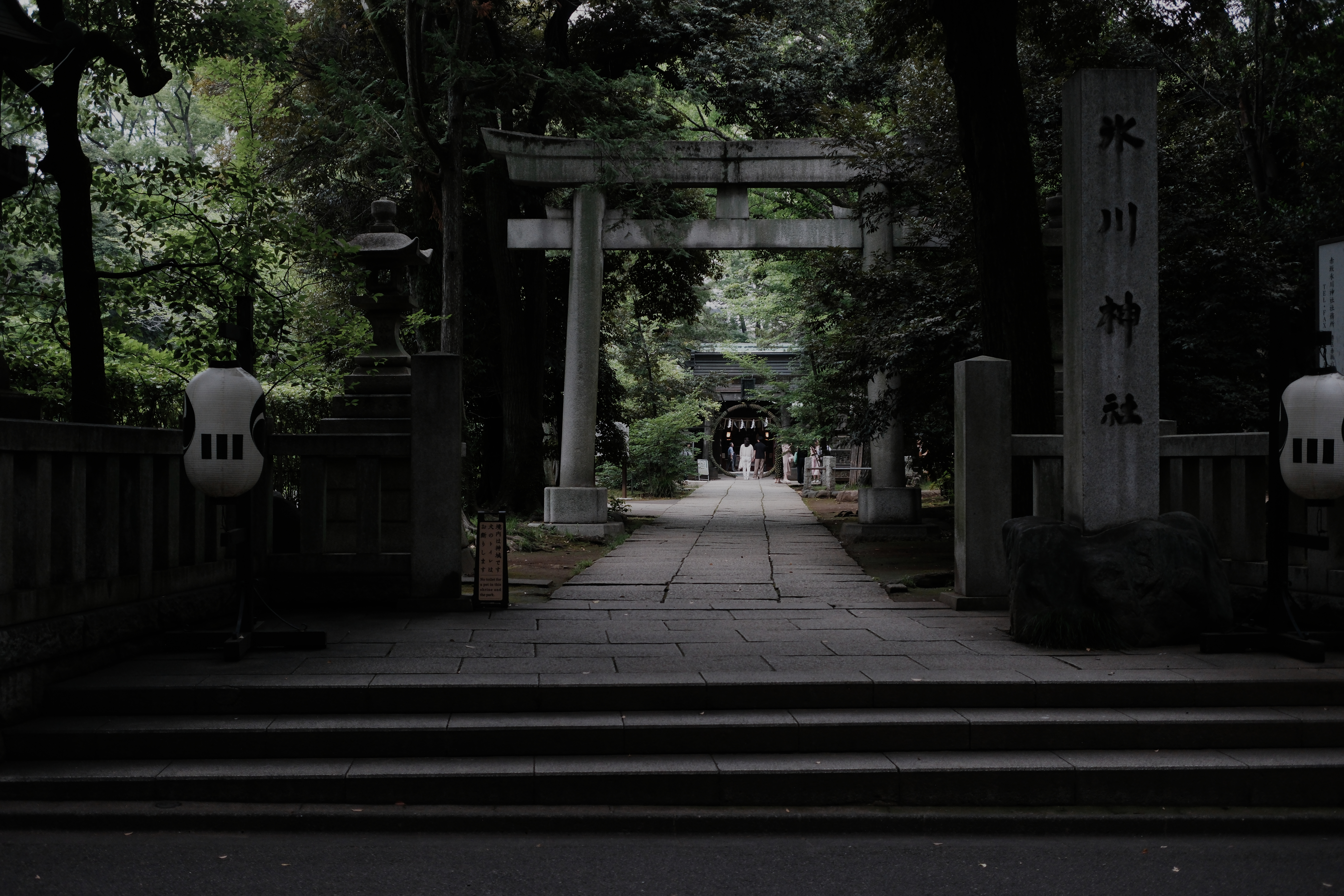 Temple roof, gravestones, apartment stairwell, and glass towers in one frame